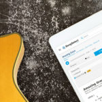 Guitar laying next to iPad display lyrics on SongSelect