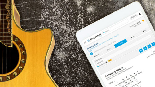 Guitar laying next to iPad display lyrics on SongSelect
