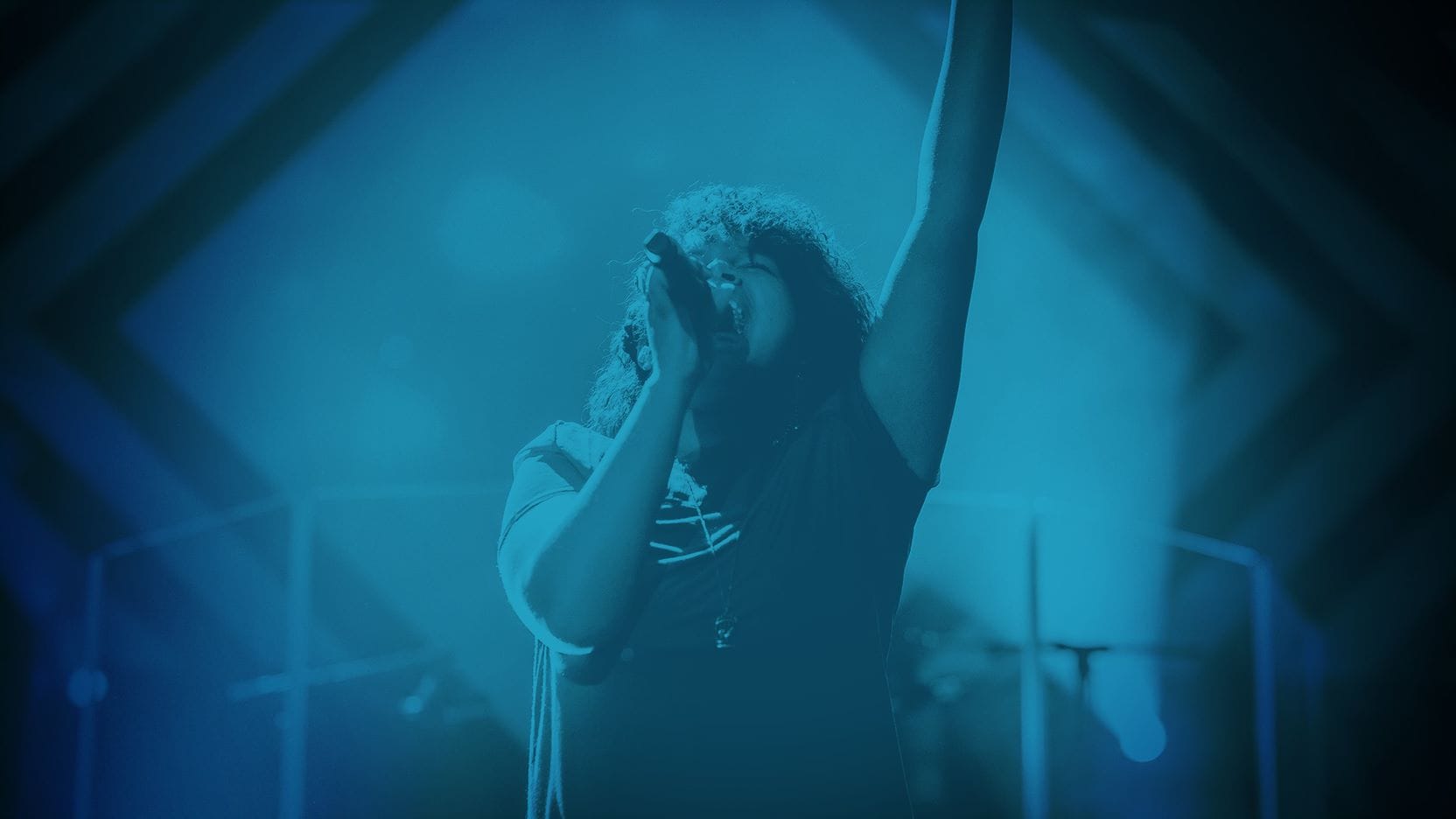 Woman singing with hand raised in worship