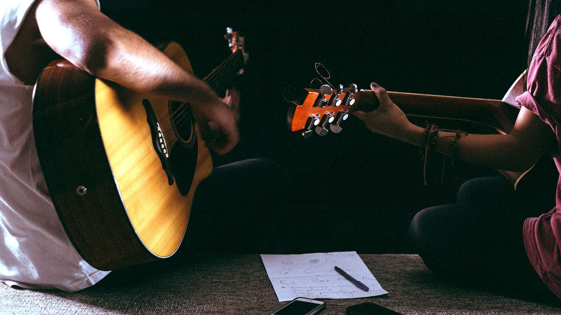 Two people playing acoustic guitar