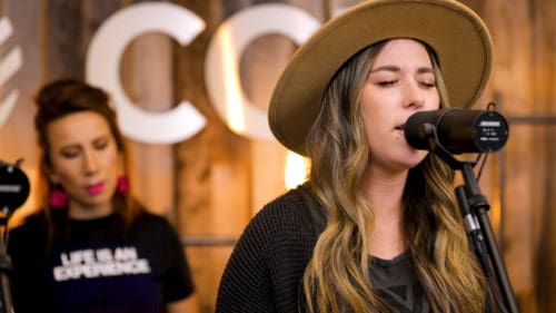 Close up of G12 Worship singer performing We Invite You, with Paola drumming in the background